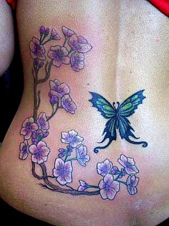 Tatuaje para mujeres de rama con flores y mariposa en la espalda