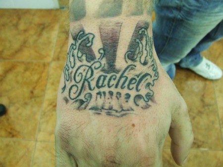 Tatuaje de un nombre entre olas en la mano