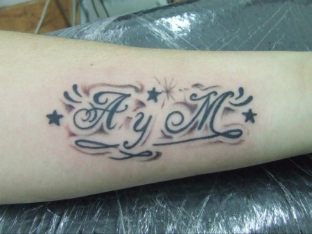 Tatuaje de unas iniciales entre estrellas