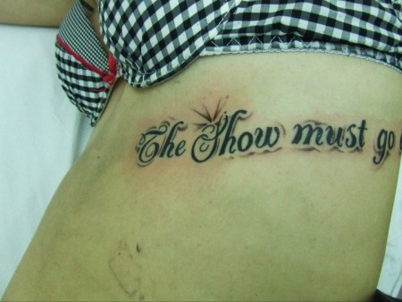 Tatuaje de una frase en las costillas de una mujer