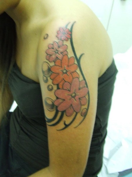 Tatuaje para mujeres. Flores y burbujas en el brazo