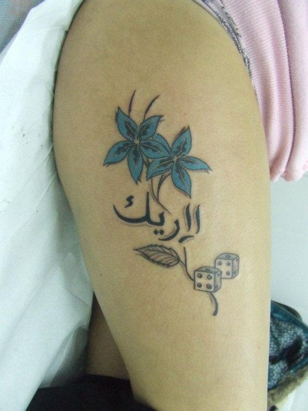 Tatuaje de una flor con letras arabes y dados