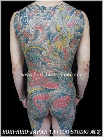 Tatuaje japonés de dragon entre nubes y agua.