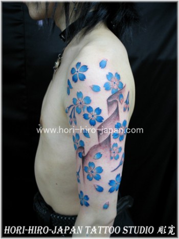 Tatuajes de flores y pétalos con viento, en el brazo