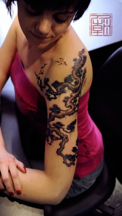 Tatuaje de un árbol chino en el brazo
