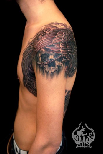 Tatuaje de calavera y fénix en el brazo