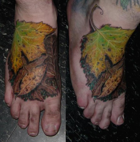 Tatuaje de varias hojas descomponiendose en el pie