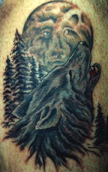 Tatuaje de un lobo aullando a la luna