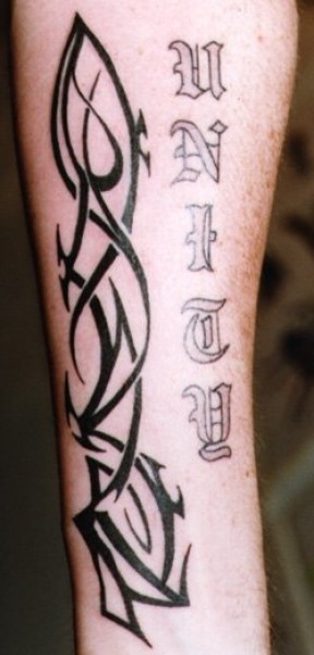 Tatuaje de un tribal en la pierna con un nombre en letras góticas