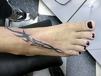 Tatuaje de mariposa con tribal en el pie