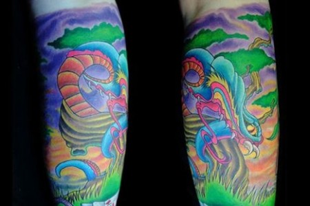 Tatuaje de una amenazadora serpiente delante de un árbol