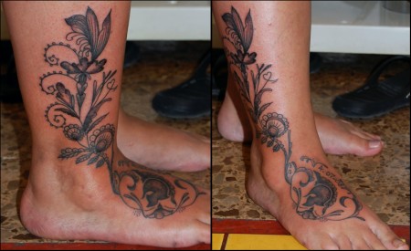 Tatuaje de una flor en el pie con una mariposa y un casco de legionario