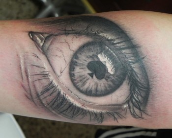 Tatuaje de un ojo con una pica por pupila
