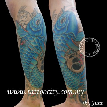 Tatuaje de una carpa subiendo entre olas por la pierna