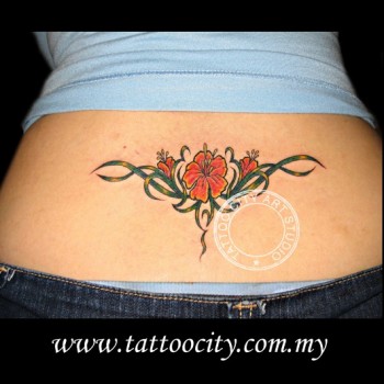 Tatuaje de unas flores y unas hojas como tribales en la rabadilla