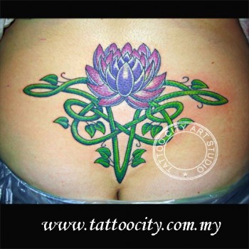 Tatuaje de una flor de loto con una planta de forma céltica encima del culo de una chica