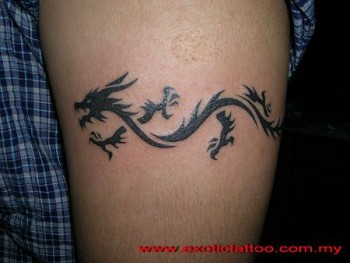 Tattoo de un pequeño dragón rodeando el brazo