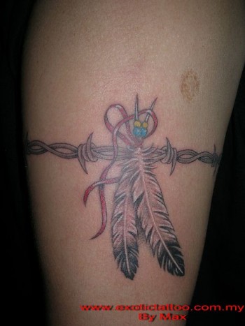 Tatuaje de un brazalete de alambre de espino con unas plumas indias atadas