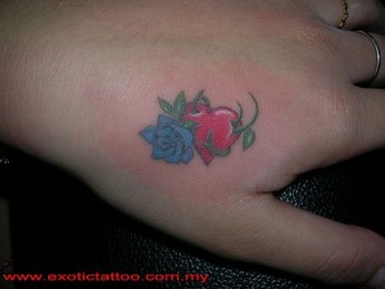 Tatuaje de un corazón atravesado por una rosa en la mano