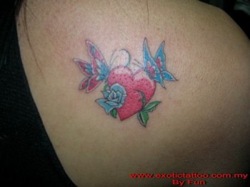 Tatuaje de un corazón con una rosa y dos mariposas