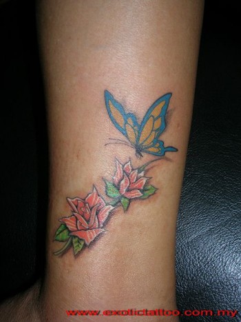 Tatuaje de una mariposa volando hacia unas flores