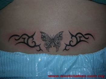 Tatuaje de una mariposa entre dos tribales
