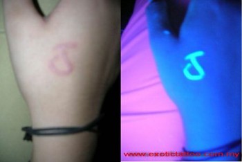 Tatuaje de una inicial en la mano con tinta ultravioleta