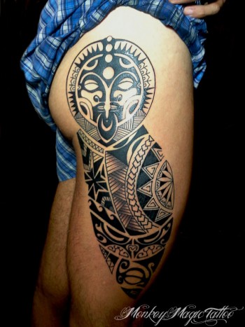 Tatuaje de una cara maori en el culo y la pierna