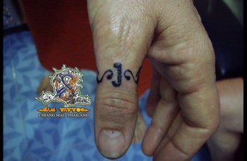 Tatuaje de un anillo tribal en el dedo pulgar