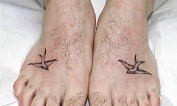 Tattoo de una pequeña golondrina en cada pie