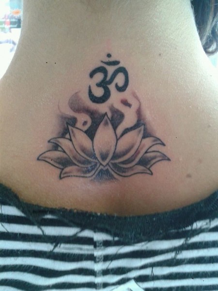 Tatuaje en blanco y negro de una flor de loto y el om en la nuca