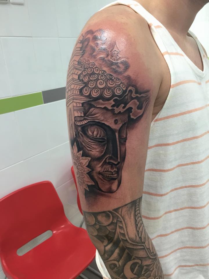 Tatuaje de una cara de buda con una pagoda