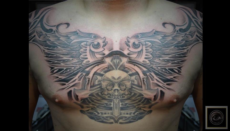 Tatuaje de una calavera y unas alas en el pecho