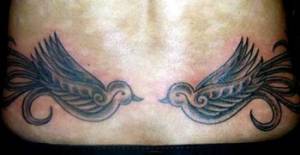 Tatuaje de dos pajaritos en la parte de abajo de la espalda