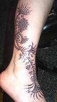 Tatuaje para mujeres, de unas flores en la pierna y pie