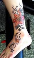 Tatuaje de flores y tribales en el tobillo y empeine