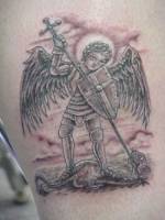 Tatuaje de un ángel guerrero matando a un dragón.
