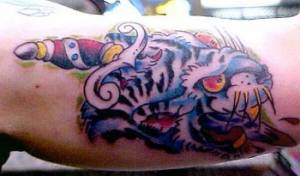 Tatuaje de la cabeza de un tigre, atravesada por un puñal