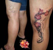 Tatuajes de flores y tribales en la pierna. Cover de una cicatriz