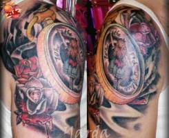 Tatuajes de rosas en el brazo junto con un broche