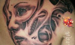 Tatuaje de unas caras saliendo de dentro la piel