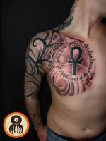 Tatuaje de tribales en el brazo y pecho al estilo japonés