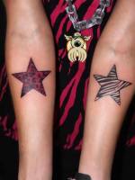 Tatuajes de dos estrellas en el antebrazo. Una como si fuera de zebra y la otra con estilo leopardo