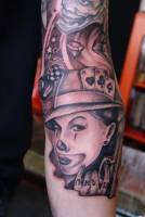 Tatuaje de una chica payaso, con algunas cartas en el sombrero