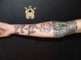 Tatuaje de una fecha y un brazalete maorí