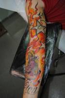 Tatuaje en el brazo lleno de fuego con estrellas