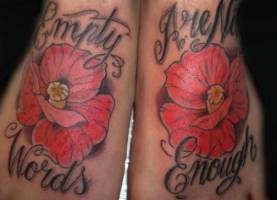 Tatuaje de unas frases y unas flores en el los pies