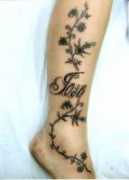Tatuaje de un nombre entre una rama de planta