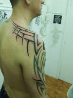 Tatuaje de un tribal en brazo y hombro