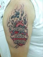 Tatuaje de un corazón en llamas con algunos nombres